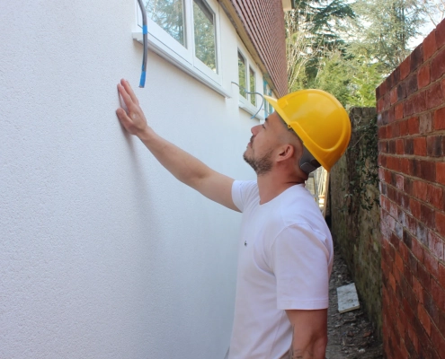 Aries Plastering Surrey team member applying smooth plaster to an interior wall