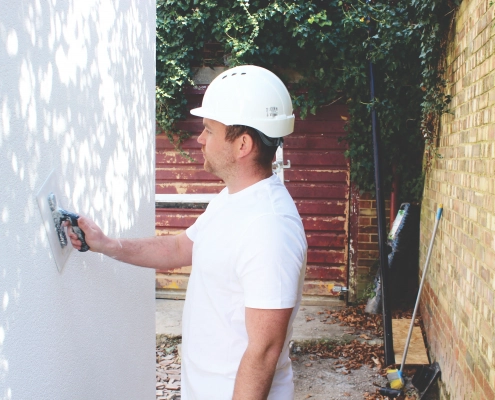 Aries Plastering Surrey team member applying smooth plaster to an interior wall