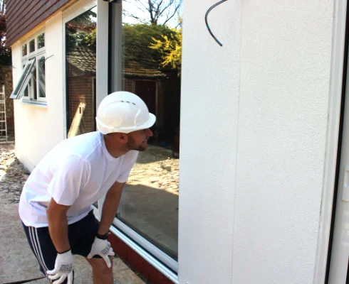 Aries Plastering Surrey team member applying smooth plaster to an interior wall