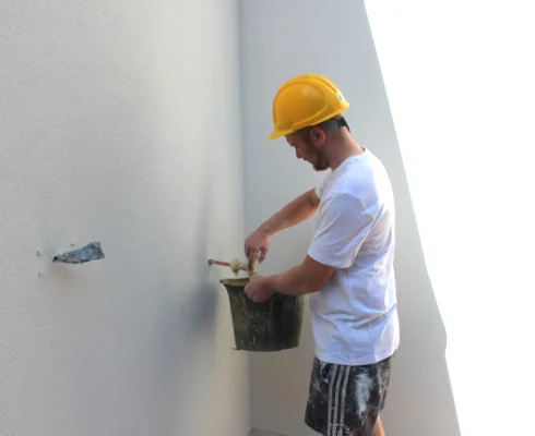Aries Plastering Surrey team member applying smooth plaster to an interior wall